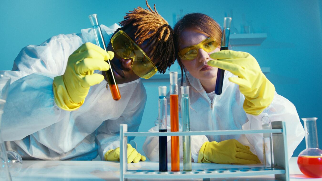 Two people experimenting with test tubes and liquids.